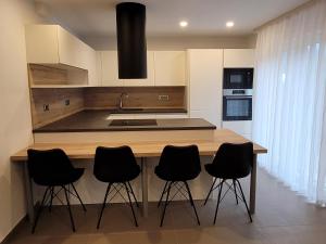 uma cozinha com um balcão de madeira com bancos pretos em Apartment river Nadiža Podbela em Podbela