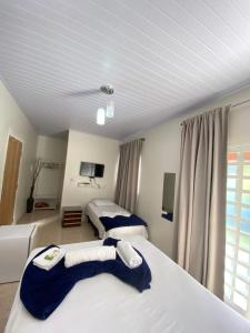 um quarto de hotel com duas camas e uma televisão em Mambaí Inn em Mambaí