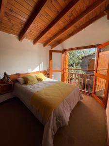 ein Schlafzimmer mit einem Bett und einem großen Fenster in der Unterkunft Paihuen Luxury Suites in Los Reartes