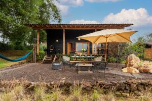 un patio con mesa y sombrilla en El Aile San Simón, en Valle de Bravo