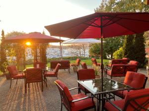 un patio con mesas, sillas y sombrillas en The Latch Inn en Sidney