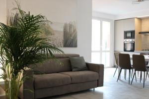 a living room with a brown couch and a kitchen at GF Holiday Suite 3 in Varazze