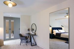 1 dormitorio con espejo, mesa y cama en Archstone House en Blackburn