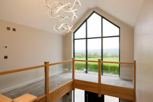 a room with a large window and a staircase with a chandelier at Mylstone House in Blackburn