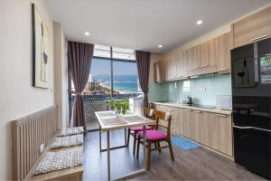 a kitchen with a table and chairs with a view of the ocean at Modern Seaview Apt next to Walking St & My An Beach in Da Nang