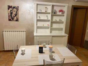 ein Esszimmer mit einem Tisch, Stühlen und Regalen in der Unterkunft Appartamento Antonietta-Assisi in Santa Maria degli Angeli