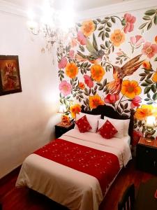 a bedroom with a bed with a floral wall at Casona Dorada Hotel Cusco in Cusco