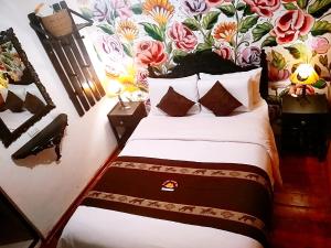 a bedroom with a bed with a floral wall at Casona Dorada Hotel Cusco in Cusco