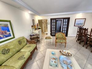 a living room with a couch and a table at Pitangueiras 3 quartos aconchegante , esquina com a praia e shopping in Guarujá