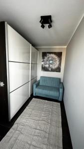 een woonkamer met een blauwe bank en een tapijt bij Apartament Festiwalowy in Opole