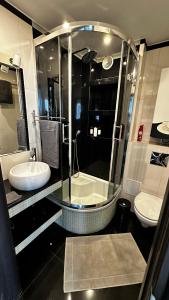een badkamer met een glazen douche en een wastafel bij Apartament Festiwalowy in Opole