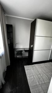 een kamer met een koelkast, een tafel en een tapijt bij Apartament Festiwalowy in Opole
