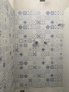 Baño con azulejos azules y blancos en la pared en Aparta Hotel Mediterráneo Estadio, en Medellín