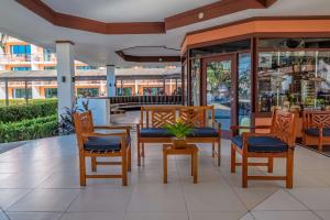 a restaurant with wooden chairs and a table with a plant at Best Western Jaco Beach All Inclusive Resort in Jacó