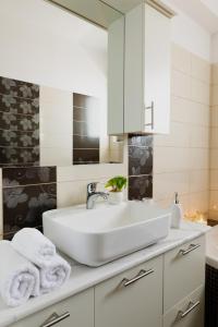 a bathroom with a white sink and a mirror at Odyssea Sea View Apartment one minute from the sea in Kremasti