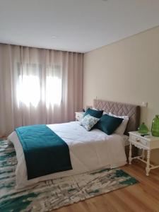 a bedroom with a large bed and a window at Casa do Alfaiate - Douro in Peso da Régua