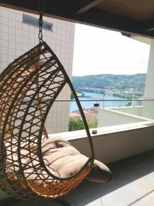 a hanging hammock in a room with a large window at Casa do Alfaiate - Douro in Peso da Régua