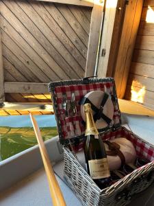 a basket with a bottle of champagne on a boat at Laivu Māja in Alūksne