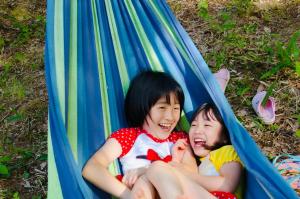two young girls sitting in a hammock at アウトドア貸切別荘北軽井沢1 in Saikubo +10 photos