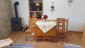 une salle à manger avec une table et un vase de fleurs. dans l'établissement Casa Caminho da Ponte, à Monção