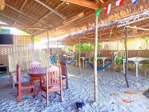 patio con mesa, sillas y parque infantil en BH Beachfront Mini Glamping Tent, en El Nido