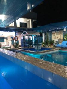 una gran piscina de agua azul por la noche en ANGZIA Private Pool & Resort Calamba, en Calambá