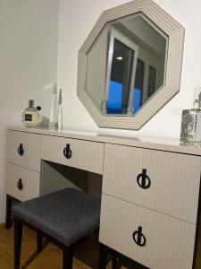 a dressing table with a mirror and a stool at Era Home Deluxe in Murg