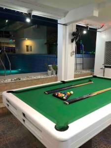 una mesa de billar con bolas de taco encima en ANGZIA Private Pool & Resort Calamba, en Calambá