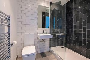 a bathroom with a toilet and a sink and a shower at ShyWharf in London