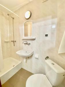 een witte badkamer met een toilet en een wastafel bij NOCLEGI NOVA in Krasnobród