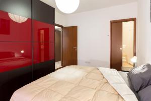 um quarto com uma cama e uma parede vermelha em [Strategico Rho Fiera-Milano] Vanzago Home Deluxe em Vanzago
