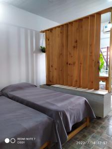 - une chambre avec 2 lits et un mur en bois dans l'établissement AxD Tresandi, à General Pico