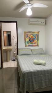 a bedroom with a bed and a mirror and a sink at Pousada Querência Maceió in Maceió