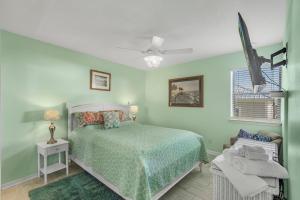 1 dormitorio verde con 1 cama y 1 silla en Sea Breeze 316 by Vacation Homes Collection en Gulf Shores
