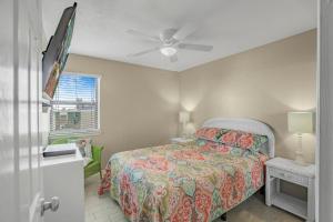 una camera da letto con un letto e un ventilatore a soffitto di Sea Breeze 316 by Vacation Homes Collection a Gulf Shores