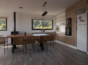 cocina con mesa, sillas y nevera en Casa en la naturaleza con vistas a las Sierras en La Cumbre