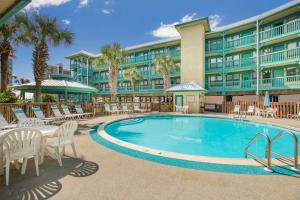 un complejo con piscina, sillas y un edificio en Sea Breeze 316 by Vacation Homes Collection en Gulf Shores