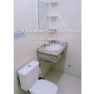 ボンビーニャスにあるResidencial Vitóriaのバスルーム(白いトイレ付)、二国間のベトナム人が溺死したと書かれた看板