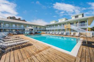 einen Pool in einem Hotel mit Stühlen und einem Gebäude in der Unterkunft The Cove 205B by Vacation Homes Collection in Gulf Shores