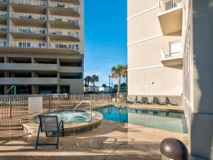 Seawind 1609 by Vacation Homes Collection في غولف شورز: حمام سباحة مع كراسي ومبنى