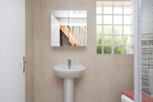 a bathroom with a sink and a mirror and a toilet at Blanc Mesnil centre ville F3 in Le Blanc-Mesnil