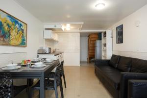 a kitchen and a living room with a table and a couch at Blanc Mesnil centre ville F3 in Le Blanc-Mesnil