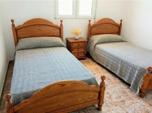 1 dormitorio con 2 camas, mesa y ventana en Preciosa Casa de Campo + Playa + Jardín + Mascotas en Naveces