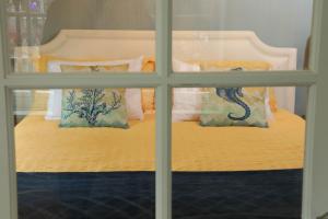 a view of a bed through a window at Enchanted Cottages by the Sea in Seaview