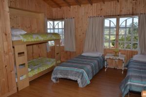 1 dormitorio con 2 literas en una cabaña en VILLA ERIKA comoda casa bellisima vista, en Paipa