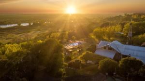 una vista aérea de una granja con la puesta de sol en el fondo en Vistalrio en San Pedro