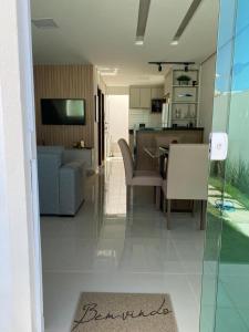 a living room with a couch and a dining room at Casa Completa com piscina, 800m da praia de Jauá in Camaçari
