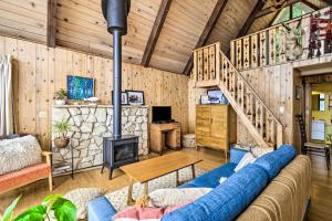 a living room with a blue couch and a fireplace at Trail's End Cabin in Lilliwaup