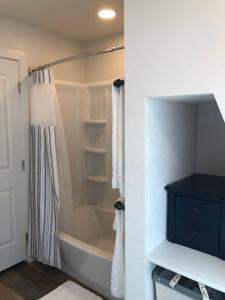La salle de bains est pourvue d'une baignoire et d'un rideau de douche. dans l'établissement Hideaway at Hunters Cove, à Lake of the Woods