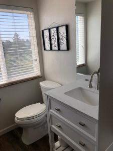 La salle de bains est pourvue de toilettes blanches et d'un lavabo. dans l'établissement Hideaway at Hunters Cove, à Lake of the Woods